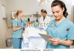 stock-photo-beautiful-nurse-using-digital-tablet-while-doctor-and-colleague-operating-male-patient-in-hospital-160486757